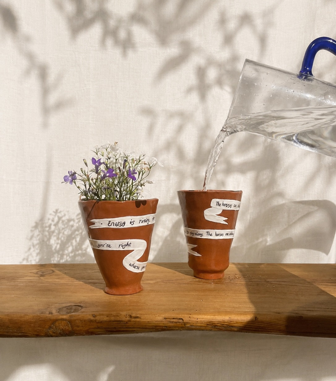 Energy Is Rising handmade ceramic ritual vessel displayed with fresh flowers and being used as a cup