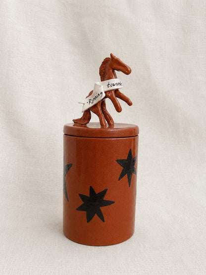 the horses are calling handmade ceramic lidded jar with star decorations and sculpted horse with ribbon on top of the lid - side angle